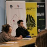Sala konferencyjna,z lewej strony stolik przy którym siedzą cztery osoby, w tle roll-upy Bardzo Młodej Kultury, Centrum Kulturalnego w Przemyślu i Radia Rzeszów.