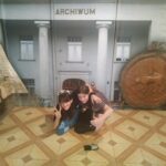 Dwie dziewczyny przed fototapetą z widokiem na fasadę Archiwum Państwowego w Przemyślu